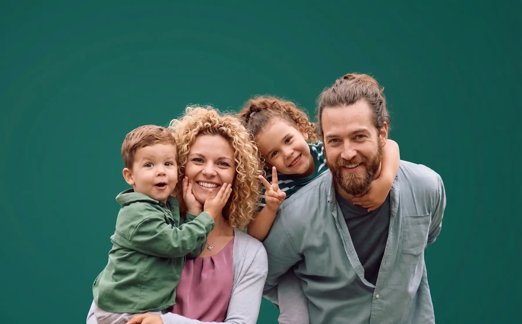 A parents sitting happily together on a bed with their children, talking about their family legacy